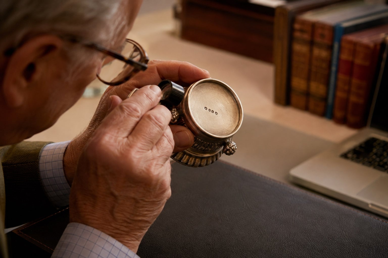 Hughes appraiser examining a maker's mark during an antique appraisal in Los Angeles